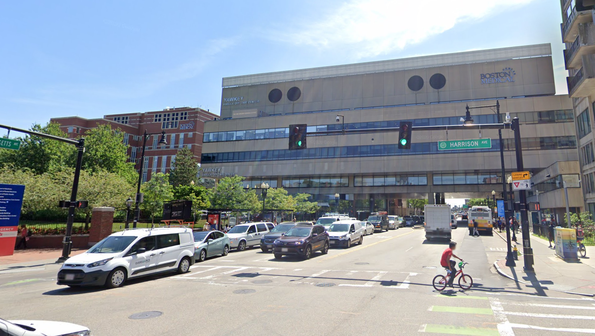 Massachusetts Avenue passes under the Boston Medical Center near Harrison Street in this 2019 Google Street View image. The City of Boston is planning a capital project that would provide a protected bikeway on this section of Mass. Ave., between Harrison Ave. and Melnea Cass Blvd.