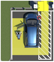 a blue electric car parked in an accessible charging station spot next to a person using a wheelchair.