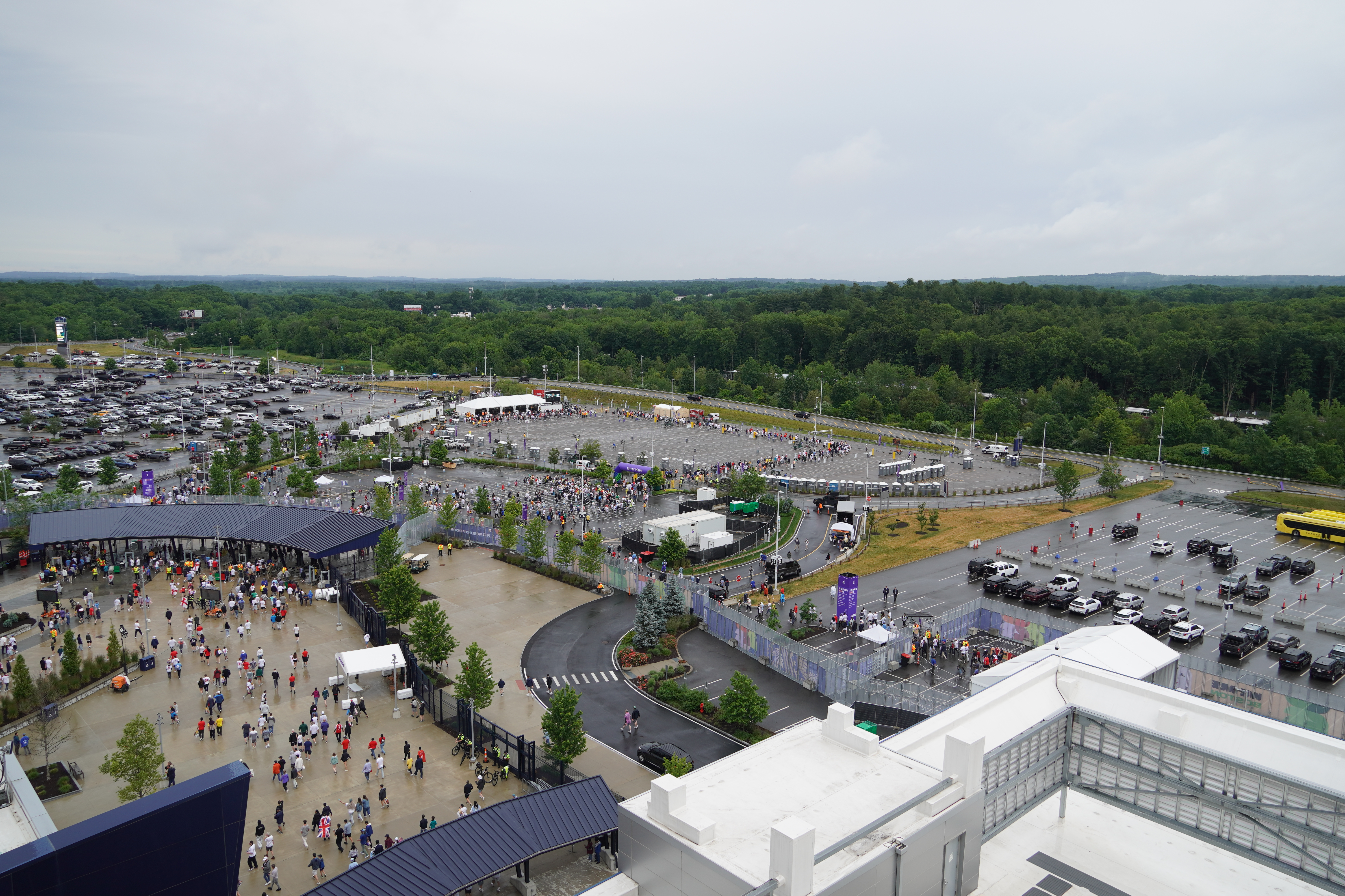 An aerial view of a stadium parking lot with a long line snaking through it.